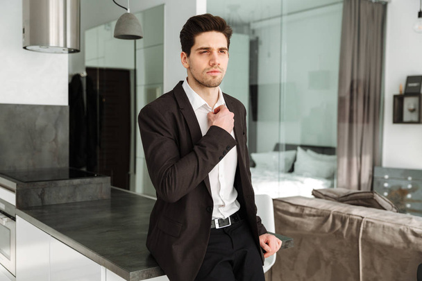 Serious young businessman standing in home - Φωτογραφία, εικόνα
