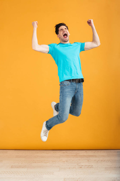 Full length portrait of a cheerful young man jumping - Photo, Image