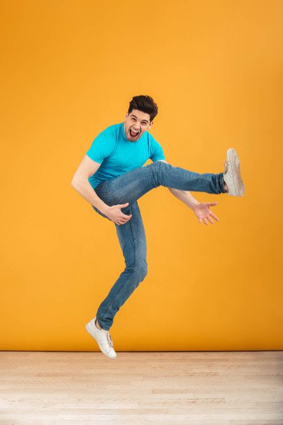 Full length portrait of a crazy young man jumping - 写真・画像