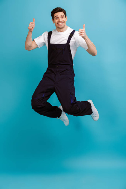 Full length image of Cheerful male builder jamping - Photo, Image