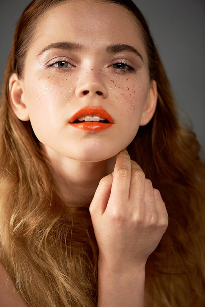 Portrait of young beautiful girl in Studio, with professional makeup.Beauty shooting. Beauty portrait of a beautiful girl with clean skin.Bright orange lips Golden freckles - Φωτογραφία, εικόνα