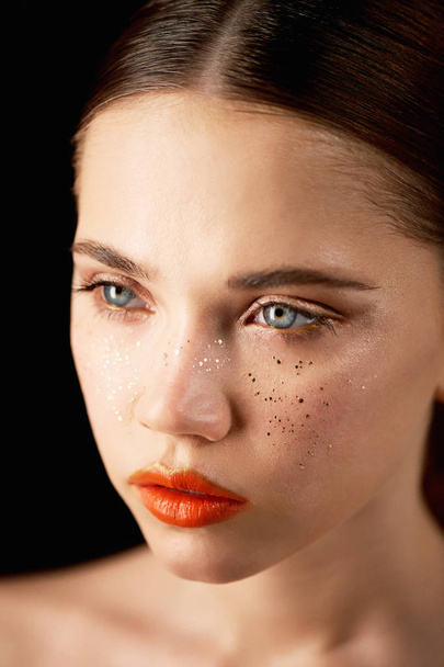 Portrait of young beautiful girl in Studio, with professional makeup.Beauty shooting. Beauty portrait of a beautiful girl with clean skin.Bright orange lips Golden freckles - Foto, imagen