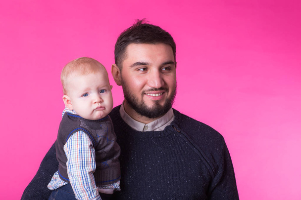 Portrét šťastný otec s malým synkem izolované na růžovém pozadí - Fotografie, Obrázek