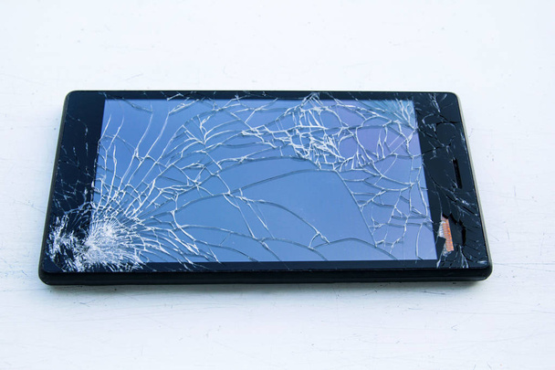 Mozgatható szúró telefon-val törött képernyő elszigetelt fehér háttérb - Fotó, kép