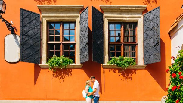 happy mature couple standing and embracing each other near a beautiful building with large chic windows - Photo, Image