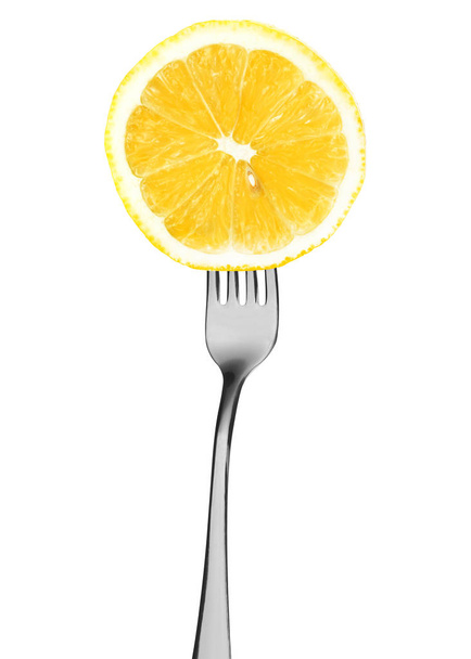 On the fork a cut slice of lemon isolated on white - Фото, изображение