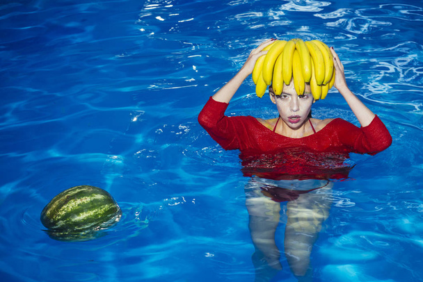 banana and watermelon on head of woman. banana and watermelon fresh fruit at girl in pool water - Foto, Imagem