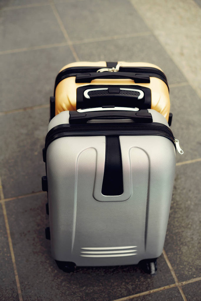 Two suitcases on grey blurred background. Summer vacation and travel concept. Traveler suitcase with copy space - Fotografie, Obrázek