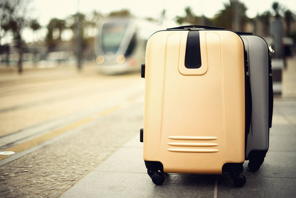 Citypass Light Rail in Jerusalem. Two suitcases standing on railway station against city train. Vacation and travel concept. Copy space, selective focus - Photo, image
