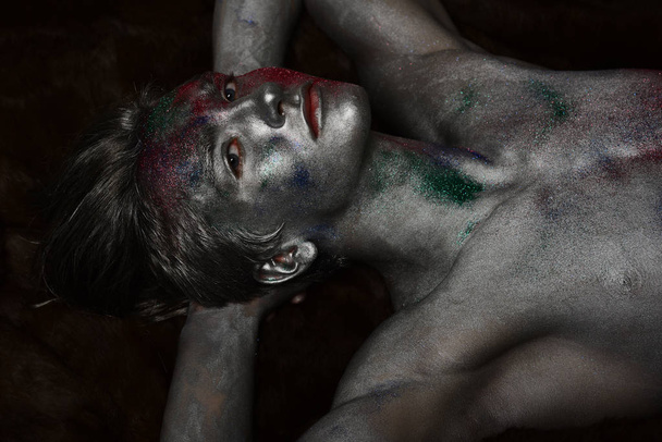 Macho covered with silver paint and colorful glitters. - Foto, immagini