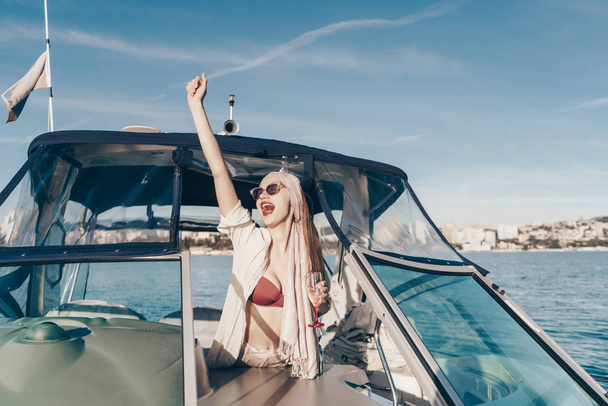 happy young girl runs her white yacht, screams and rejoices, goes on vacation to the islands - Photo, image