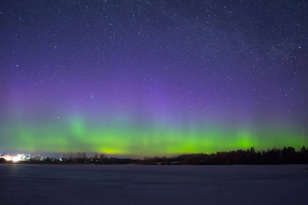 Polar northen luzes aurora boreal à noite no céu estrelado acima do lago com a ilha e as árvores de silhueta pela floresta no horizonte
. - Foto, Imagem