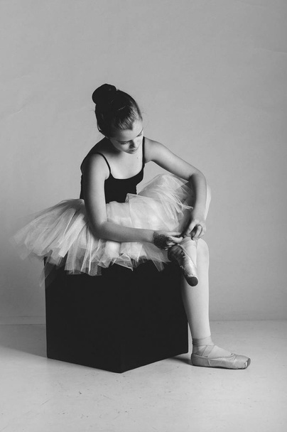 Adorable ballerina tying up her shoes - Photo, Image