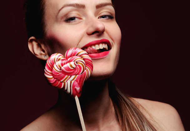 emotional girl with a lollipop over pink background - Fotoğraf, Görsel
