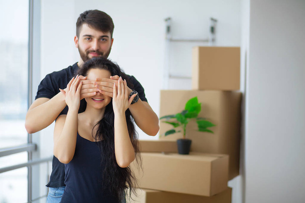 Couple showing keys to new home hugging looking at camera - Photo, Image