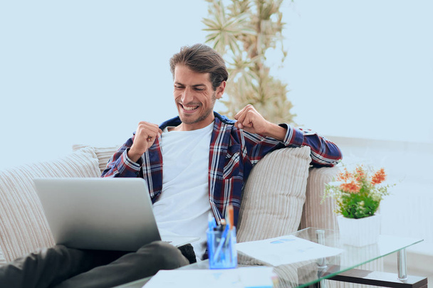 gelukkig man met laptop vanuit huis werkt. concept van het freelancen. - Foto, afbeelding