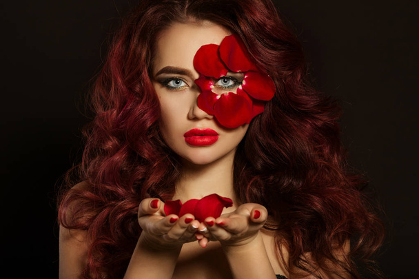 Portrait of beautiful luxury sexy woman with creative makeup and red rose petals of her face and in hands - Φωτογραφία, εικόνα