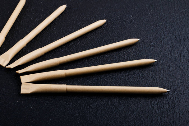 mockup design. set of beige pens on the dark wooden background. composition - Фото, изображение