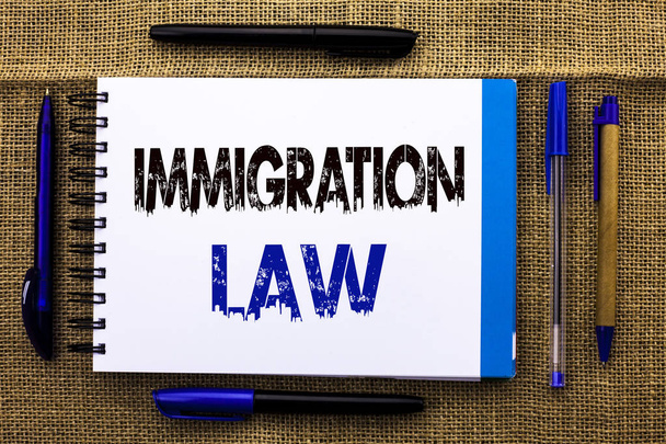 概念的な手書きの移民法を示します。ビジネス テキスト ジュート予約ノートブックに書かれた移民退去強制ルールの国民の規則の写真横にペンを背景. - 写真・画像