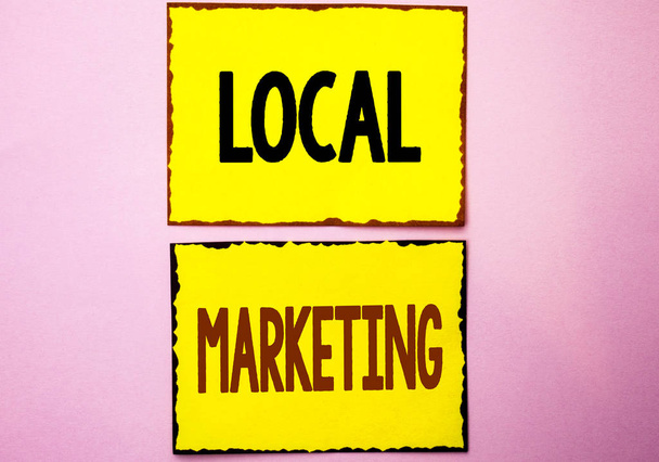 Написання тексту "Місцевий маркетинг". Концепція бізнесу для регіональної реклами Комерційні місцеві оголошення написані на жовтих липких нотатках на рожевому тлі
. - Фото, зображення