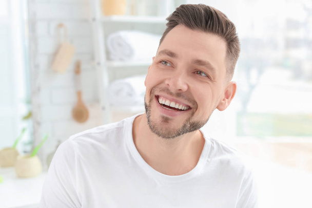 Young man with beautiful smile indoors. Teeth whitening - Foto, afbeelding
