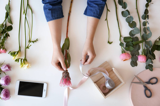 Female florist creating beautiful bouquet at table, top view - Photo, Image