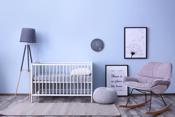 Baby room interior with crib and rocking chair near wall - Fotó, kép