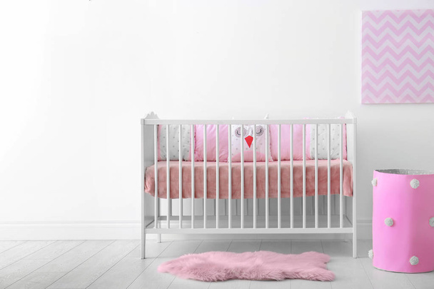 Baby room interior with crib near wall - Foto, imagen