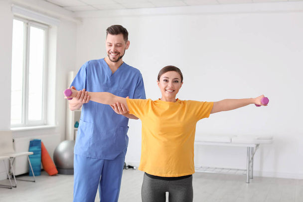 Physiotherapist working with female patient in clinic - Fotografie, Obrázek