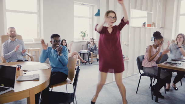 Camera follows European female boss exiting multi-ethnic modern office, doing crazy dance walk of success and victory 4K - Footage, Video