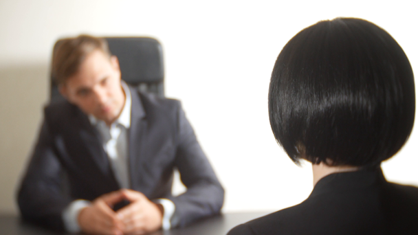 un uomo in giacca e cravatta fa domande a una donna bruna in un'intervista. 4k. intervista. reclutamento
 - Filmati, video