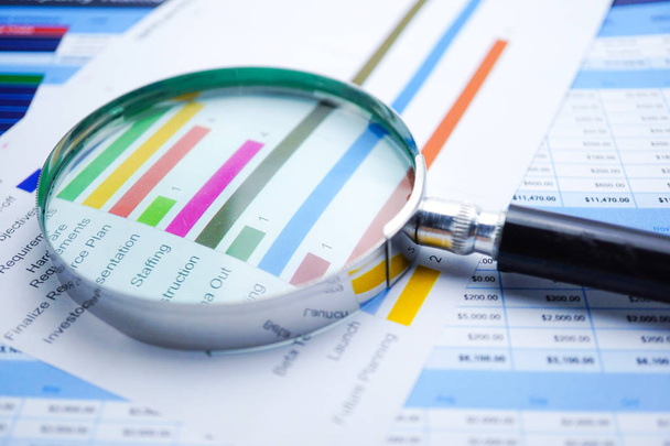Magnifying glass on Charts Graphs paper. Financial development, Banking Account, Statistics, Investment Analytic research data economy, Stock exchange trading, Mobile office reporting Business company meeting concept. - Photo, Image