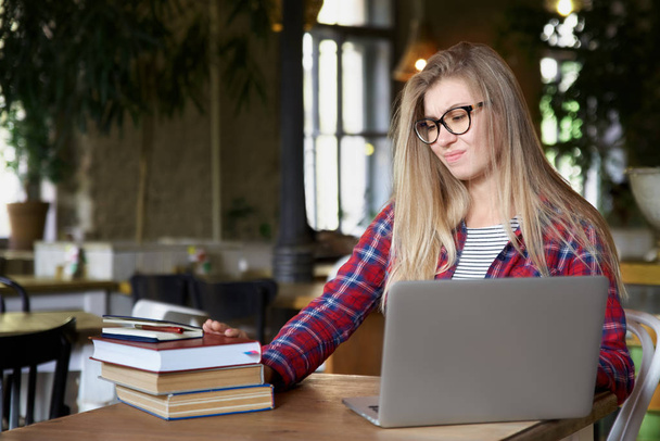 ders kitapları ve bir dizüstü bilgisayar ile bir kafede bir masada oturan genç öğrenci kız. Eğitim yorgun olduğunu - Fotoğraf, Görsel