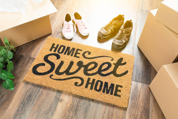 Home Sweet Home hoş geldiniz Mat, kutuları, kadın ve erkek ayakkabı ve bitki sert ahşap zemin üzerinde hareket. - Fotoğraf, Görsel