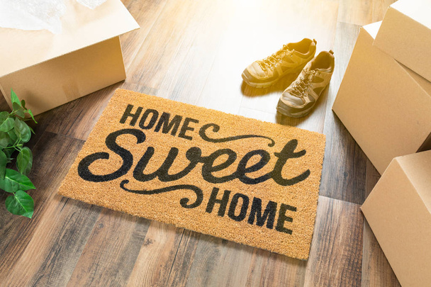 Home Sweet Home hoş geldiniz Mat, kutuları, Ayakkabı ve bitki sert ahşap zemin üzerinde hareket - Fotoğraf, Görsel