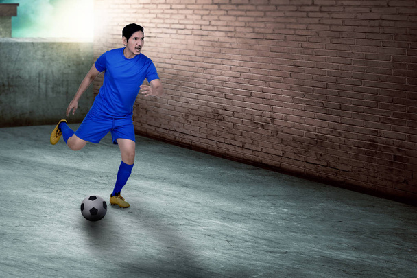Joven asiática futbolista practicando fútbol en la calle
 - Foto, Imagen