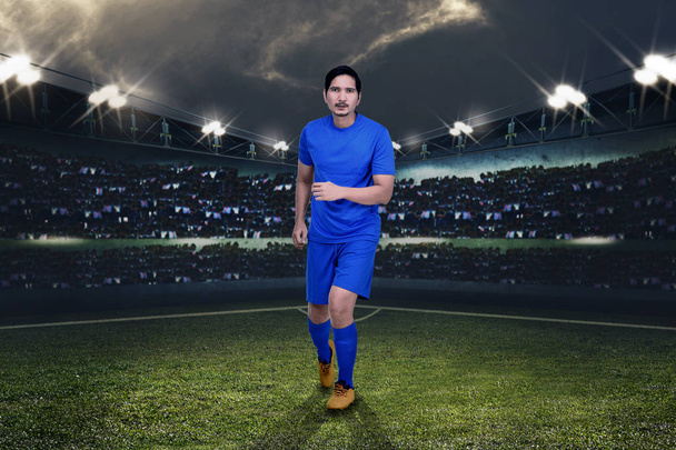 Handsome asian football player playing football on stadium - Foto, afbeelding