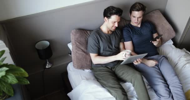 Εναέρια βολή του νεαρό ζευγάρι αρσενικό χρήση smartphone και tablet ψηφιακή - Πλάνα, βίντεο