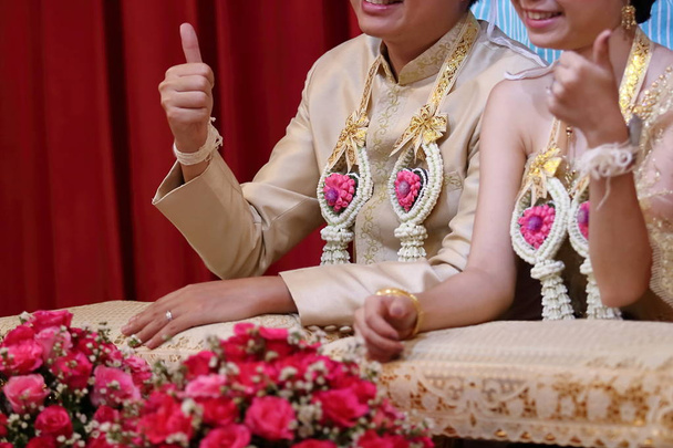 Happy time of bride and groom showing thump up sign in Thai traditional wedding ceremony. - Photo, Image