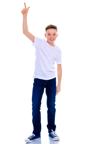 A beautiful little school boy points to something. - Foto, afbeelding