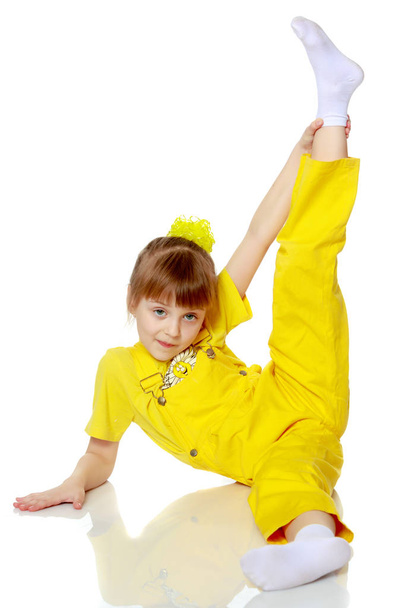 Girl with a short bangs on her head and bright yellow overalls. - Фото, зображення