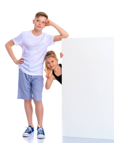A boy and a girl near an advertising white banner. - Foto, Bild