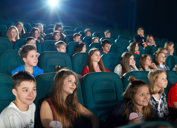 Schoolmates watching cartoon in the cinema hall. - Valokuva, kuva