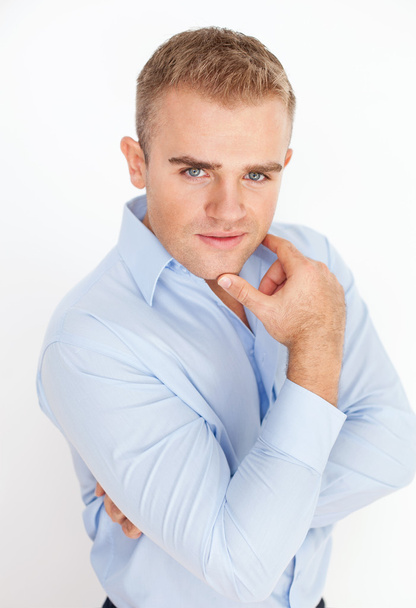Portrait of young business man holding hand up to chin with arms - Foto, afbeelding