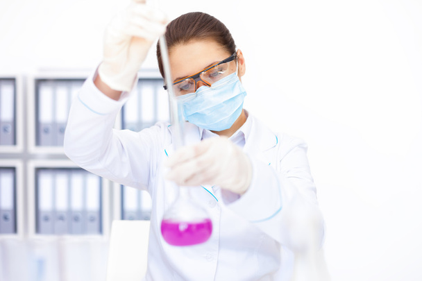 jonge chemische vrouwelijke onderzoeker werken met chemische stoffen - Foto, afbeelding