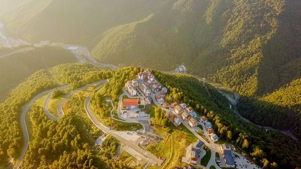 Rosa Khutor plateau, buildings, slopes and chair lifts. Aerial view at sunset  - Photo, Image