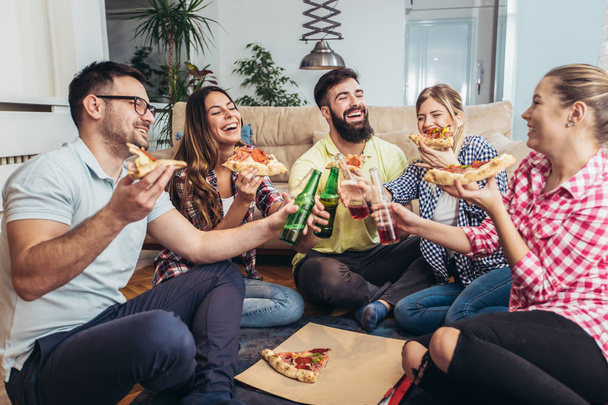 Pizza yiyen bir grup genç arkadaş. Ev partisi. Fast food konsepti.. - Fotoğraf, Görsel