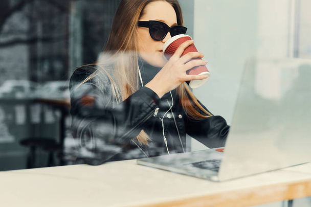 Young girl sit in coffee place in front of the window look at he - Фото, изображение