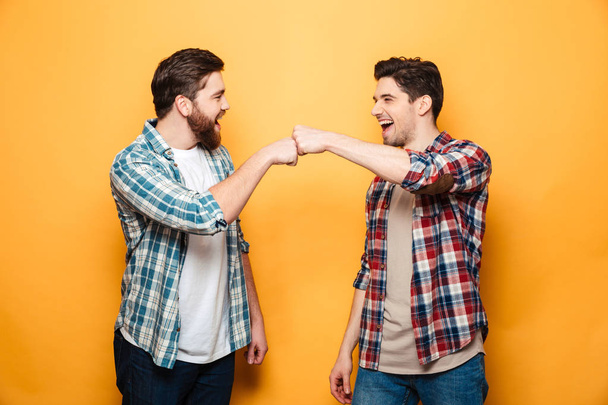 Portrait of a two happy young men giving fist bump - Φωτογραφία, εικόνα