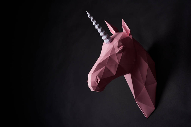 Sideview of pink powder shadowed unicorns head hanging on wall. - Photo, Image